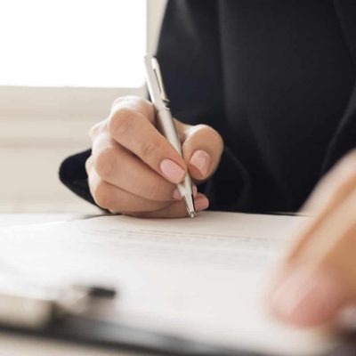 Hand signing a legal document with a pen, representing certified translation for contracts and visa applications
